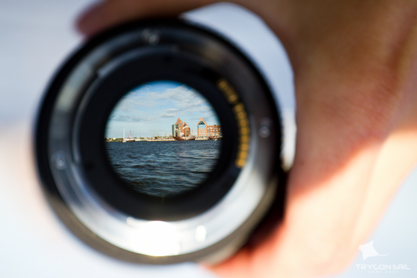 Blick durch ein Objektiv auf die Speicher der AIDA im Rostocker Stadthafen während des Events Hansesail meets Hertha Ottilie