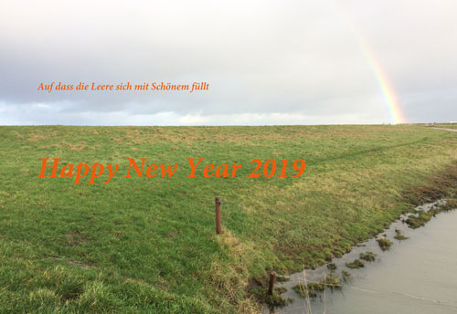Die karge Landschaft von Ostfriesland mit Deich und Entwässerungsgraben versehen mit einem Gruß zum Neuen Jahr 2019